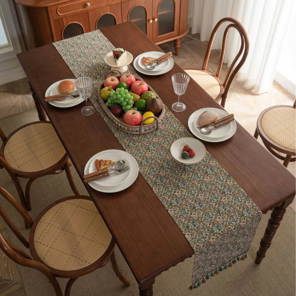 Nordic jacquard table runner with tassel trim in dark blue striped pattern laid on a wooden table.