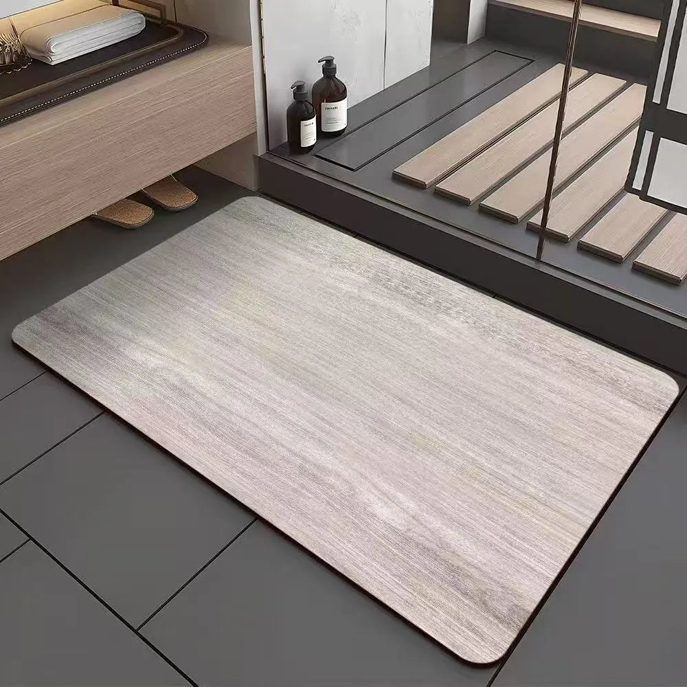 Square diatomite bathroom mat with wood grain pattern on a bathroom floor.