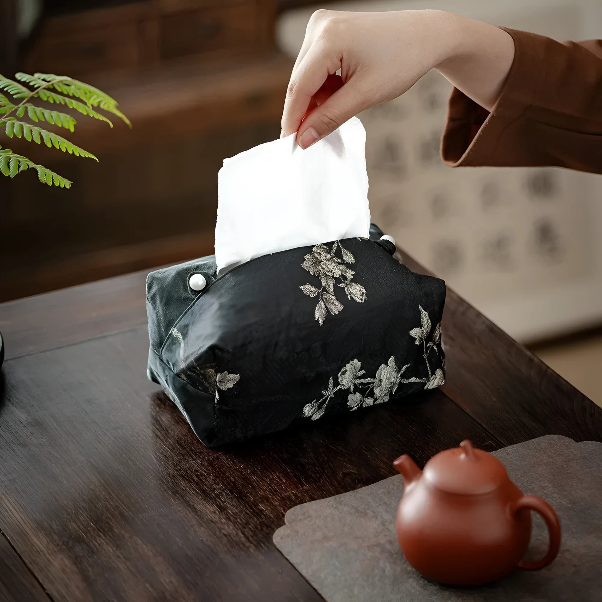 White Chinese brocade fabric tissue box with embroidered plum blossoms, shown with and without a pearl buckle clasp.