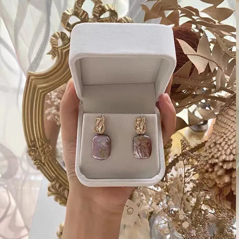 Square stud earrings with natural freshwater pearl in geometric quadrilateral setting
