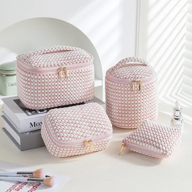Four cube-shaped polyester makeup bags in matching colour set for travel organisation