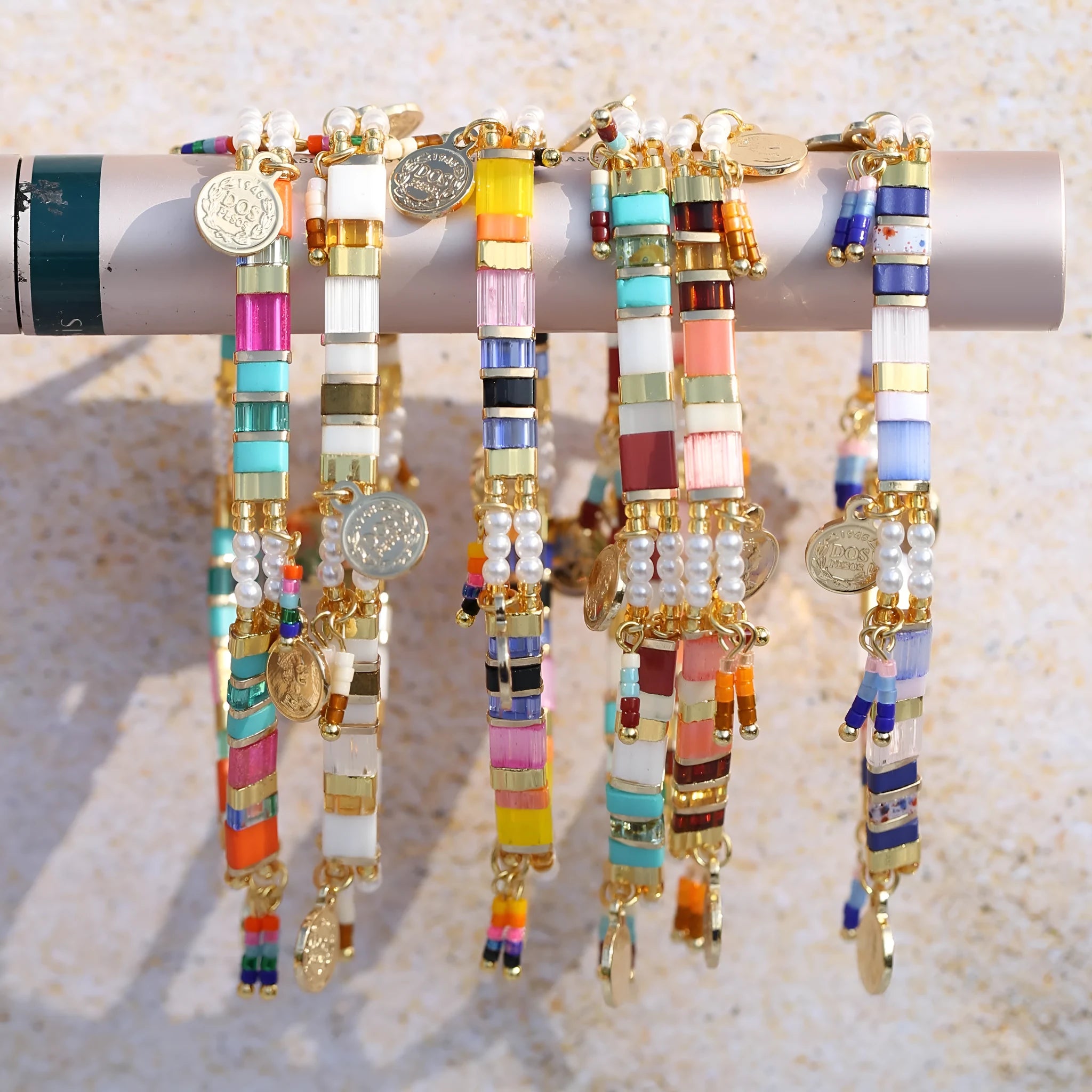 Women's bracelet with imitation pearl and coloured glass beads on wrist, showing adjustable clasp.