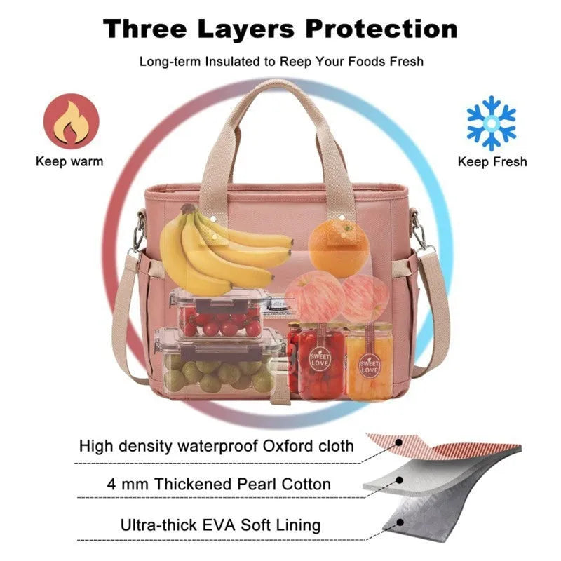Cube-shaped pink Oxford cloth picnic bag with a removable shoulder strap and side pocket, shown on a wooden table.