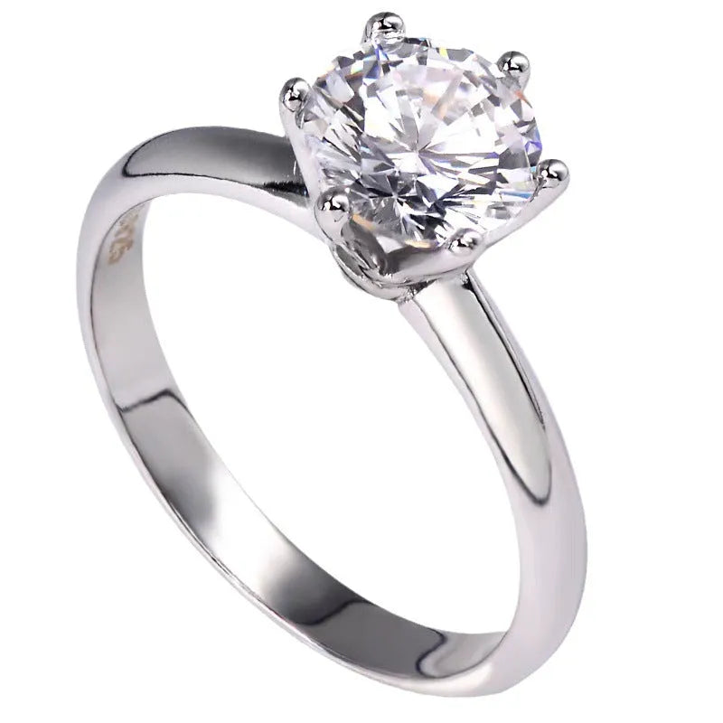 Six-claw zircon ring with geometric design and white gold plated finish shown on finger