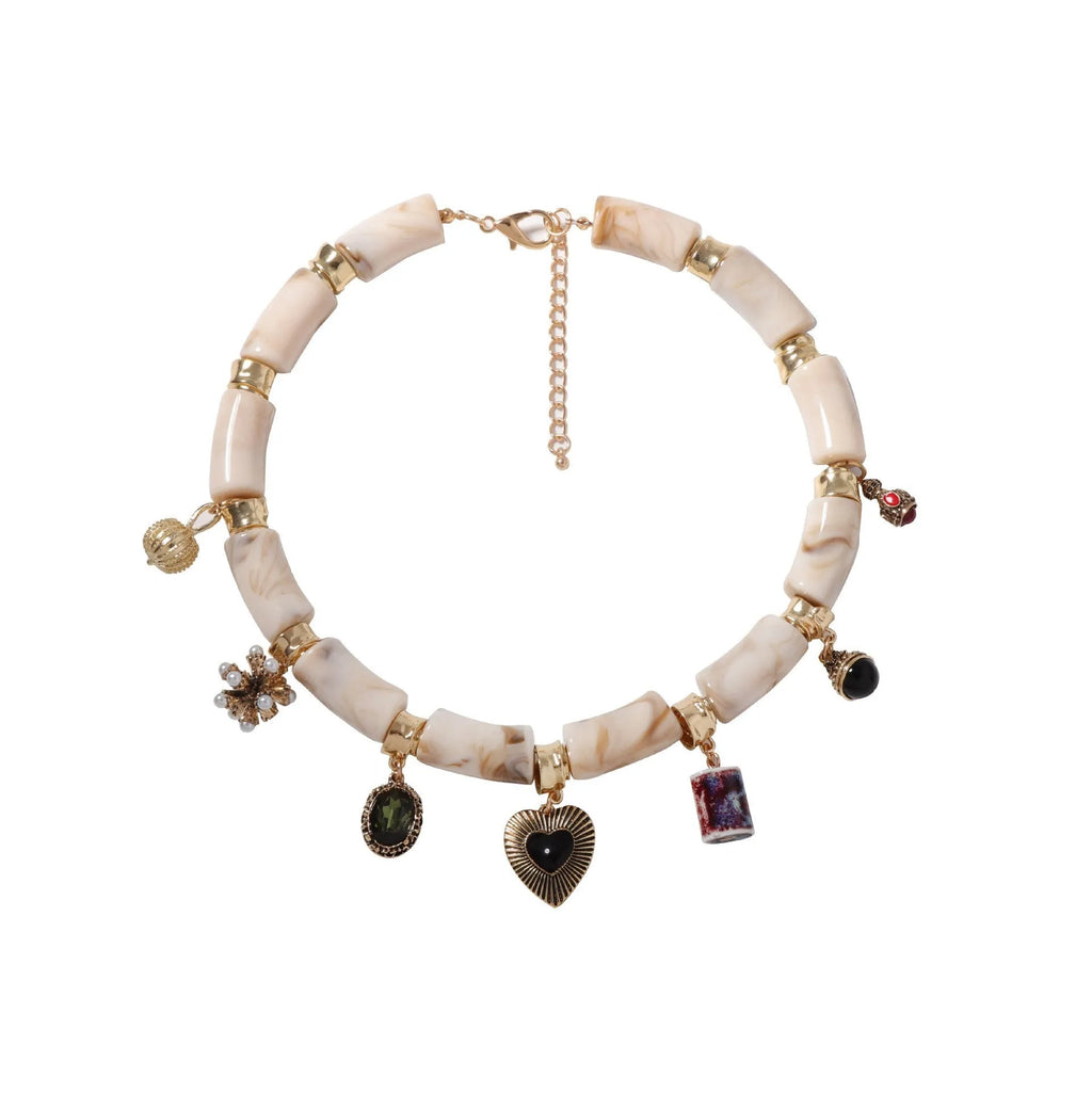 Close-up of a women's resin necklace with a heart-shaped pendant containing a bamboo detail and an electroplated metallic finish.