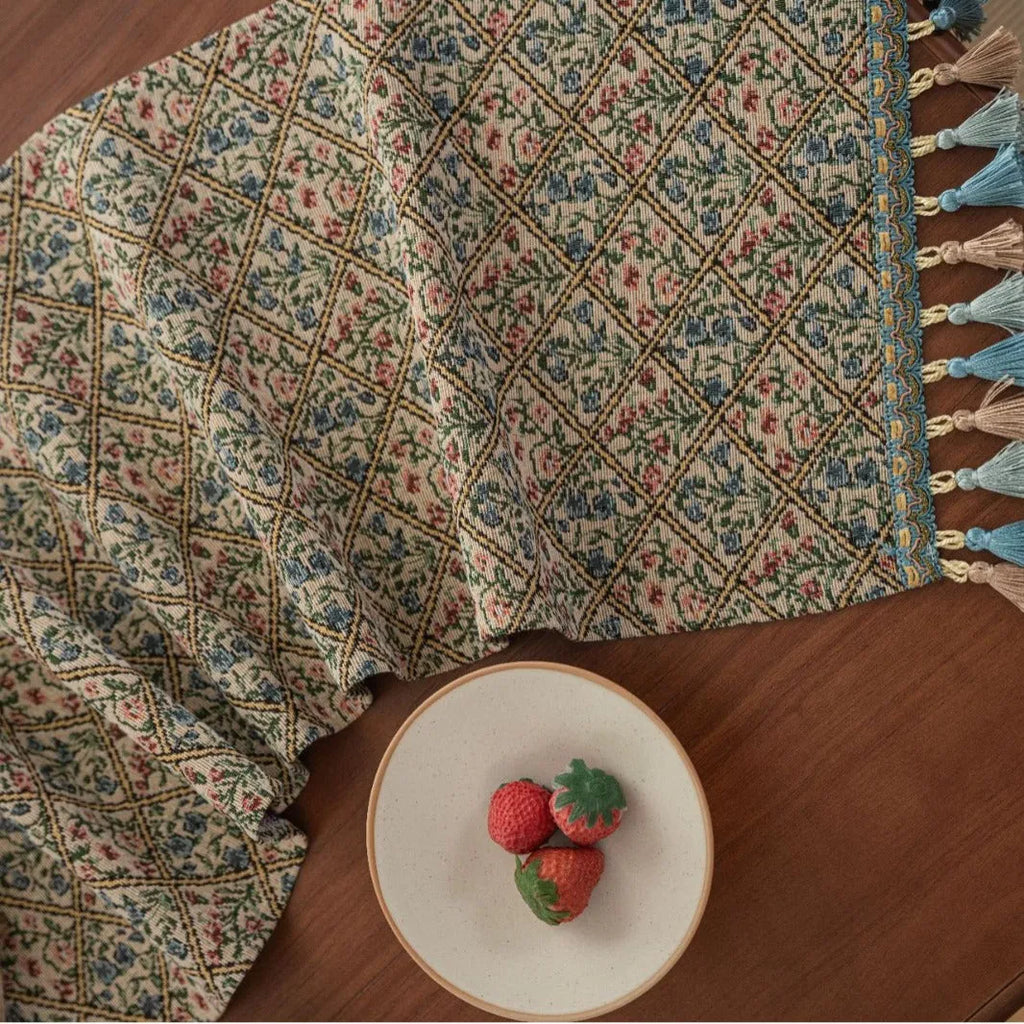 Nordic jacquard table runner with tassel trim in dark blue striped pattern laid on a wooden table.