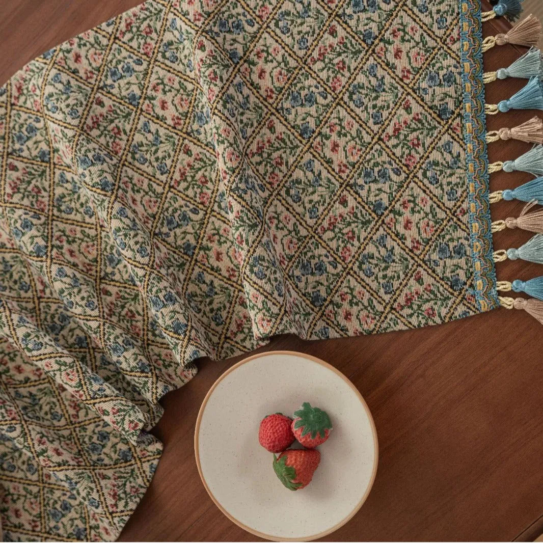 Nordic jacquard table runner with tassel trim in dark blue striped pattern laid on a wooden table.