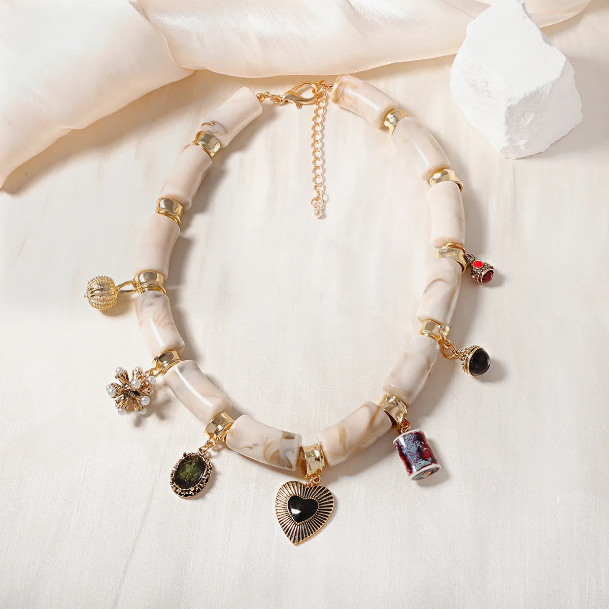 Close-up of a women's resin necklace with a heart-shaped pendant containing a bamboo detail and an electroplated metallic finish.