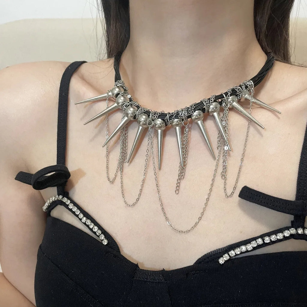 Leather necklace with round beads, a tassel, and silver rivet details on a white background.