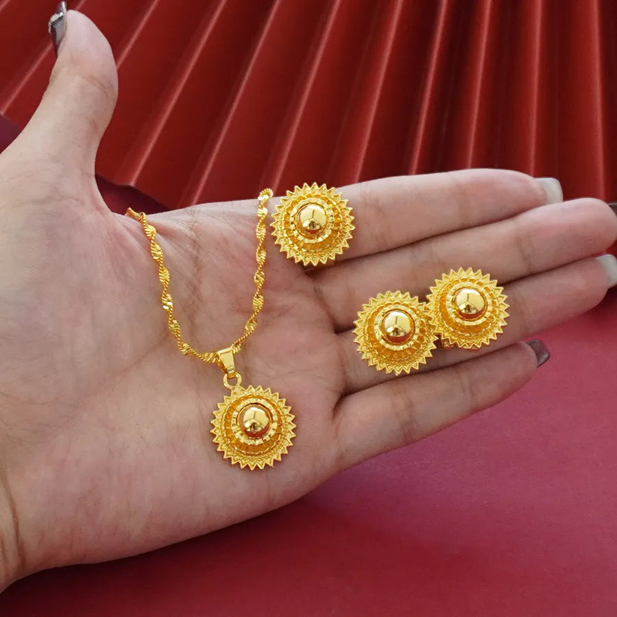 Gold-coloured three-piece jewellery set showing necklace with water wave chain, floral design earrings, and matching ring.