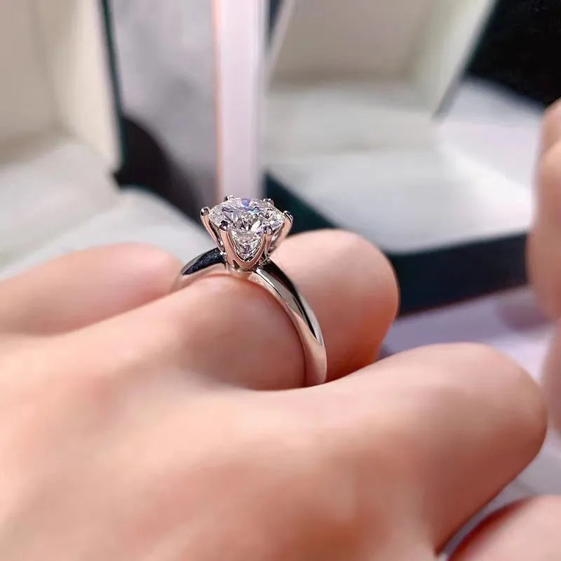 Six-claw zircon ring with geometric design and white gold plated finish shown on finger
