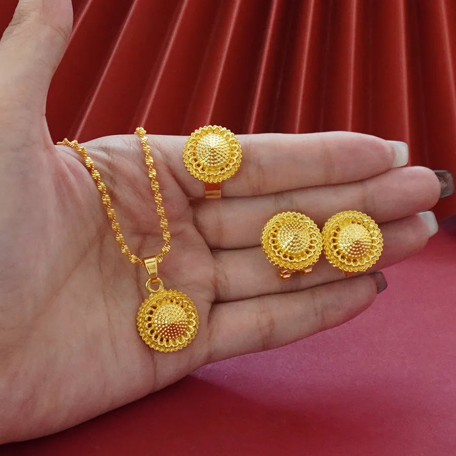 Gold-coloured three-piece jewellery set showing necklace with water wave chain, floral design earrings, and matching ring.