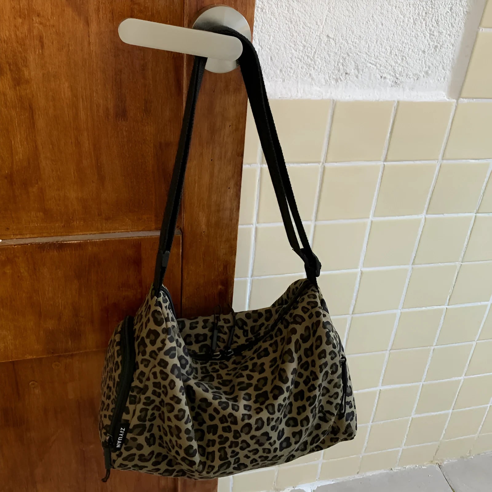 Leopard print sports style shoulder messenger bag with striped lining and stitching details