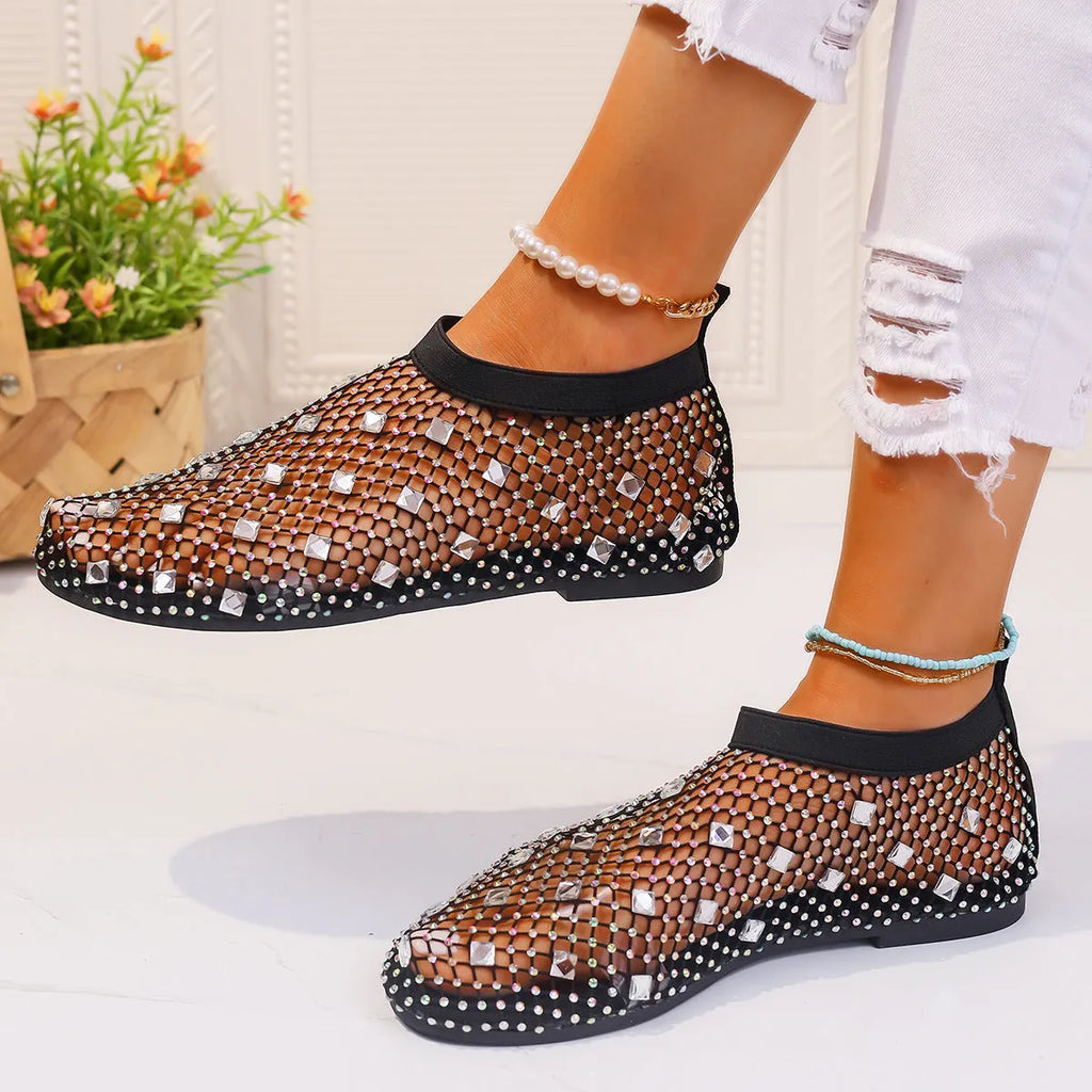 Women's flat sandals with mesh upper, colourful rhinestone decoration, and a rubber sole.