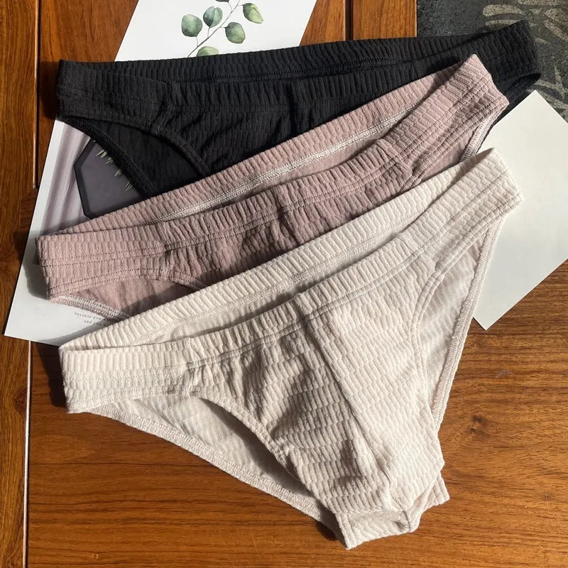 Men's solid colour cotton triangle briefs in apricot, shown from the front on a mid-waist fit model.
