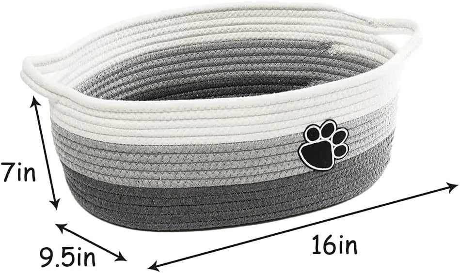 Light beige handmade cotton rope storage basket with a handle on a wooden floor.