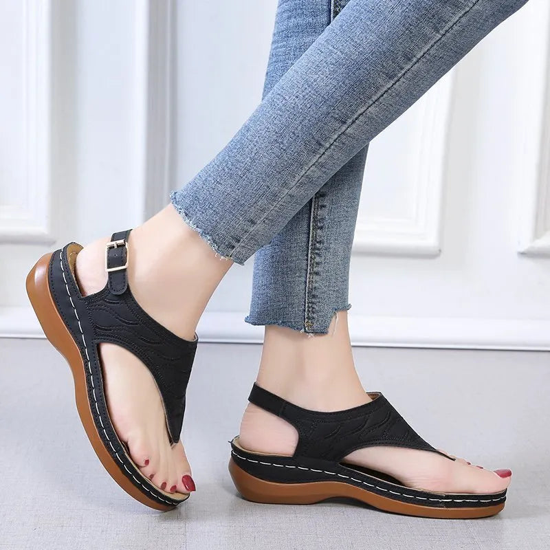 Women's wedge heel flip flop sandals in black with an adjustable buckle strap on the back.