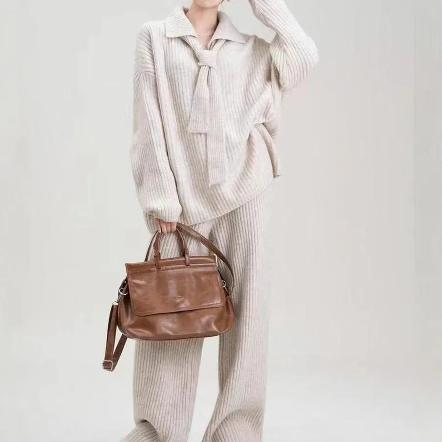 Beige sweater suit two-piece set with a knitted top and casual trousers on a hanger.