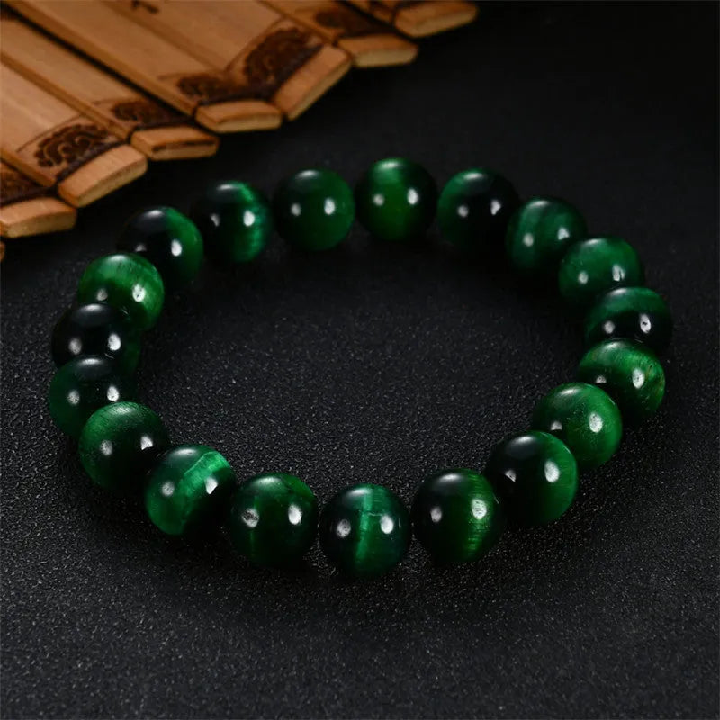 Green Natural Tiger Eye stone bracelet with geometric beads on a wrist.
