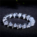 Women's white crystal bracelet with a ghost pyramid charm and Ruyi symbol, showing round beads.