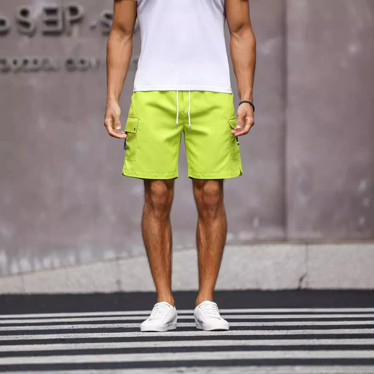 Man wearing loose fit army green straight leg workwear shorts made from cool silk cotton fabric.