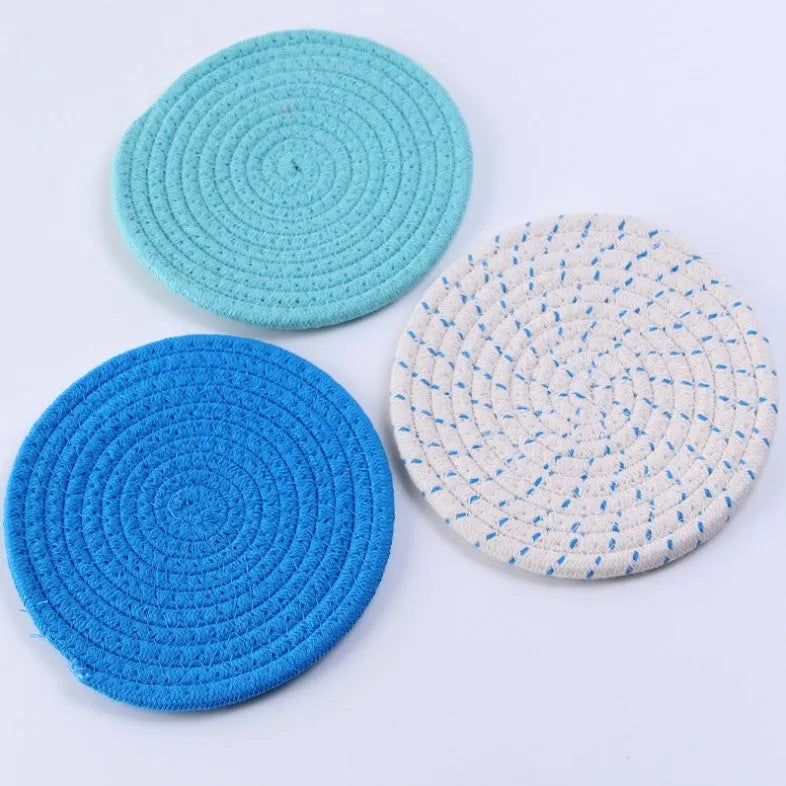 Set of three round grey cotton cord coasters, each 18 cm in diameter, on a wooden table.