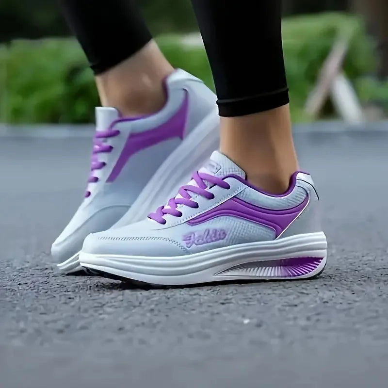 Women's grey powder heelless sports travel shoes with a mid heel on a plain background