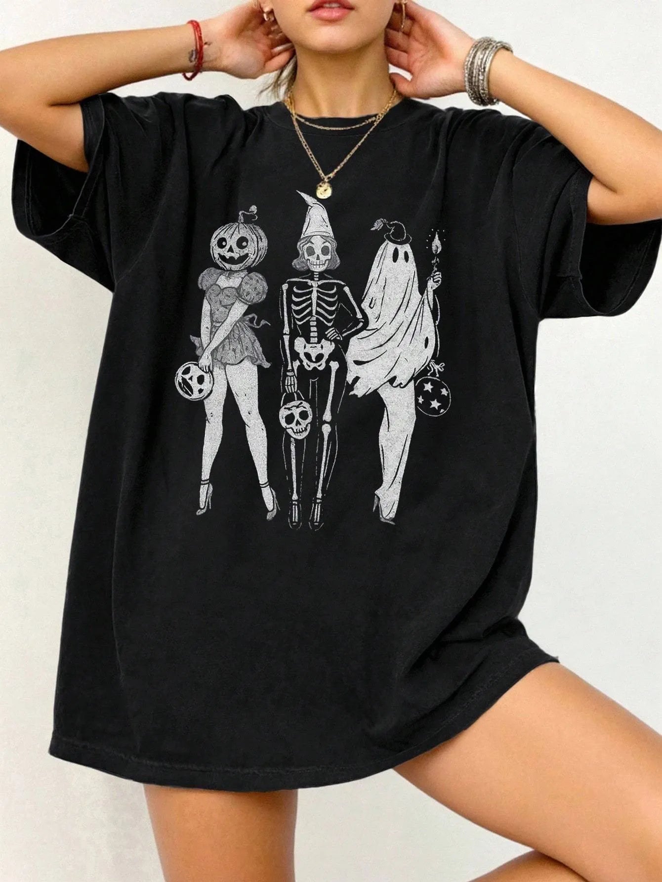 A loose-fitting black cotton T-shirt with short sleeves and a round neck on a hanger.