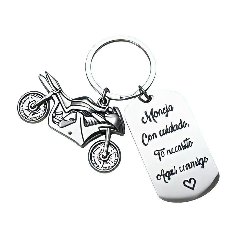 Stainless steel motorcycle keychain with a dark flannel storage pouch on a grey background.
