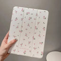 Clear iPad case with floral cartoon pattern, shown folded into a stand position.