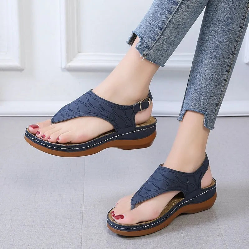 Women's wedge heel flip flop sandals in black with an adjustable buckle strap on the back.