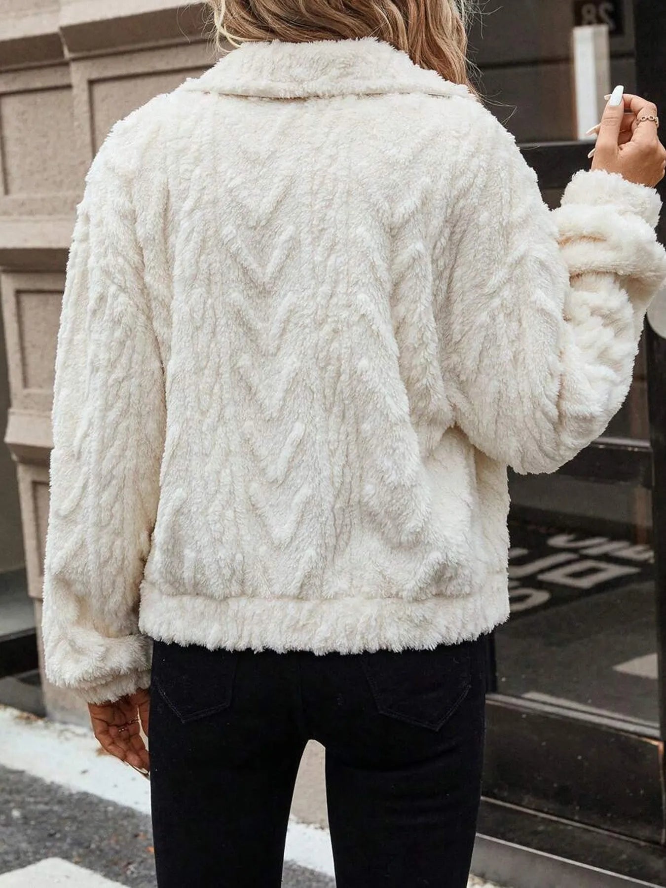 Ivory white women's cardigan coat with buttons and plush fabric on a hanger.