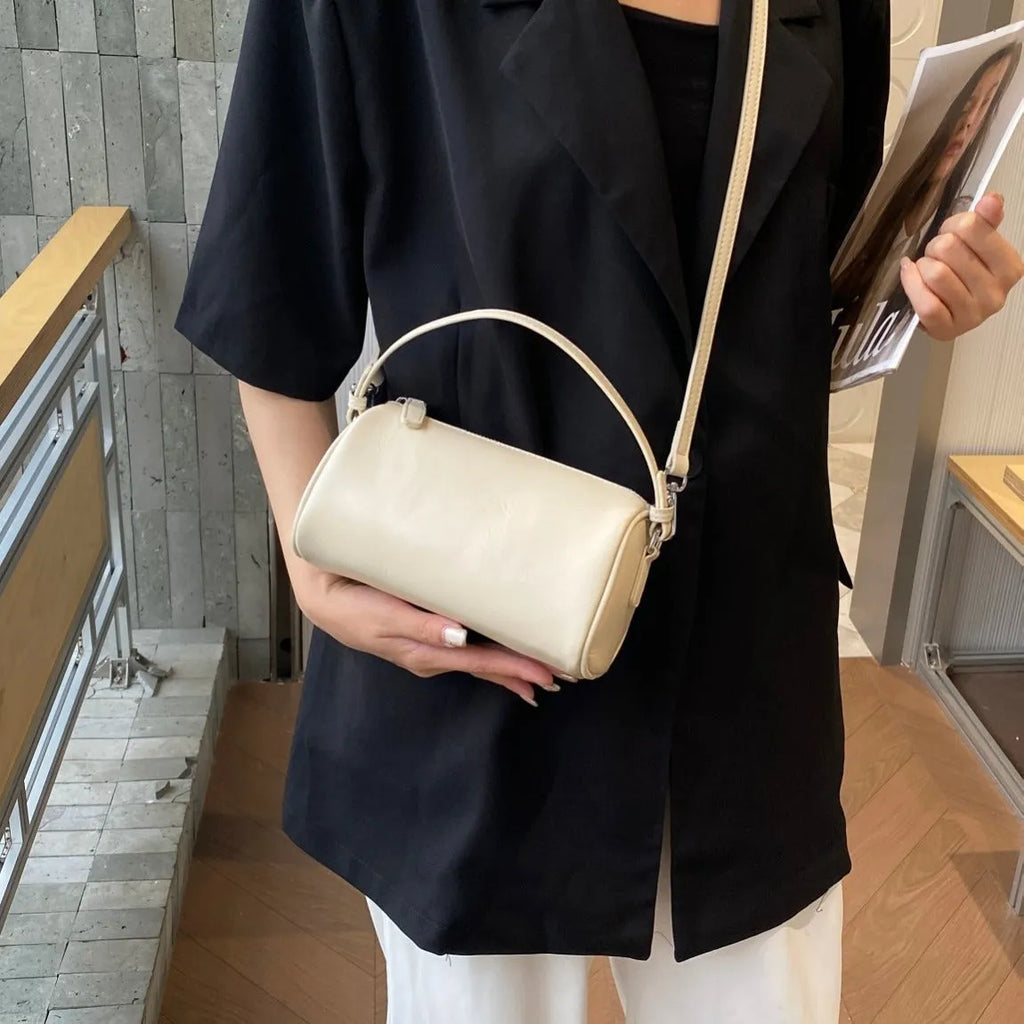 Soft brown genuine leather cylindrical crossbody phone bag with adjustable strap.