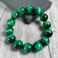 Green Natural Tiger Eye stone bracelet with geometric beads on a wrist.