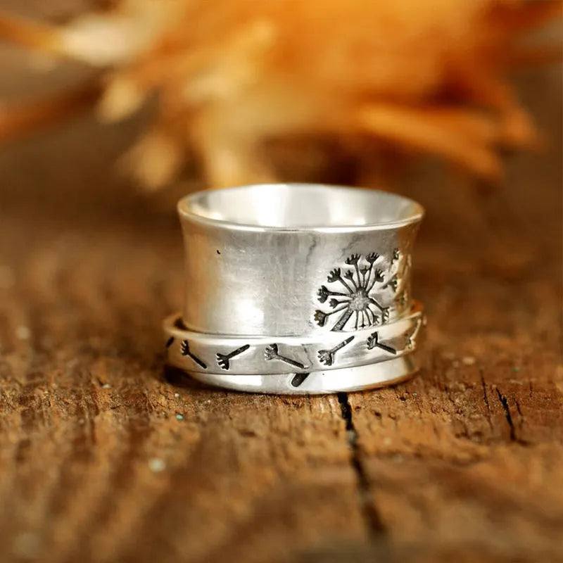Silver rotatable flower ring showing adjustable floral element on finger
