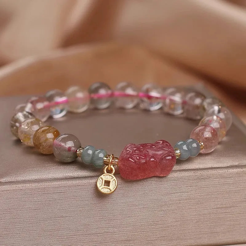 Colourful hair crystal bracelet with cat's paw, flower, butterfly, and coin purse charms on an adjustable band.
