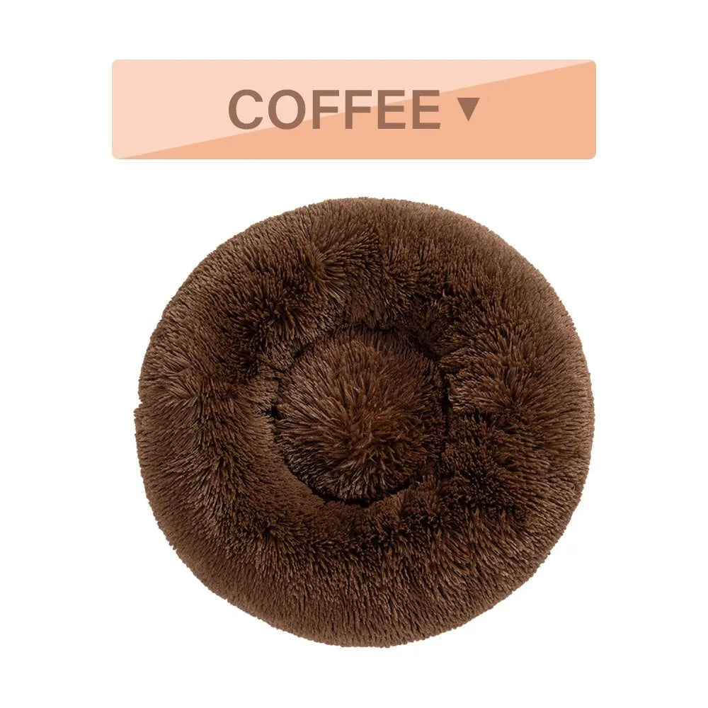 Fluffy donut-shaped dog bed in long plush material, shown in a light grey colour.