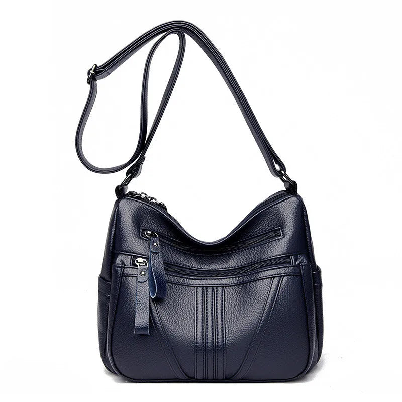 Genuine leather horizontal square messenger bag in black with contrast stitching and a front slit pocket.