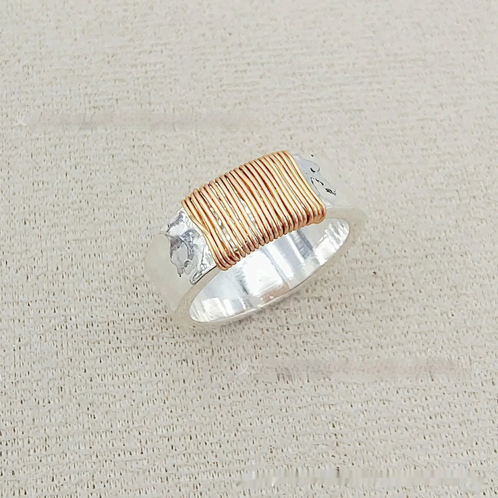 Silver golden geometric copper bracelet with an irregular coil and wide face ring design.