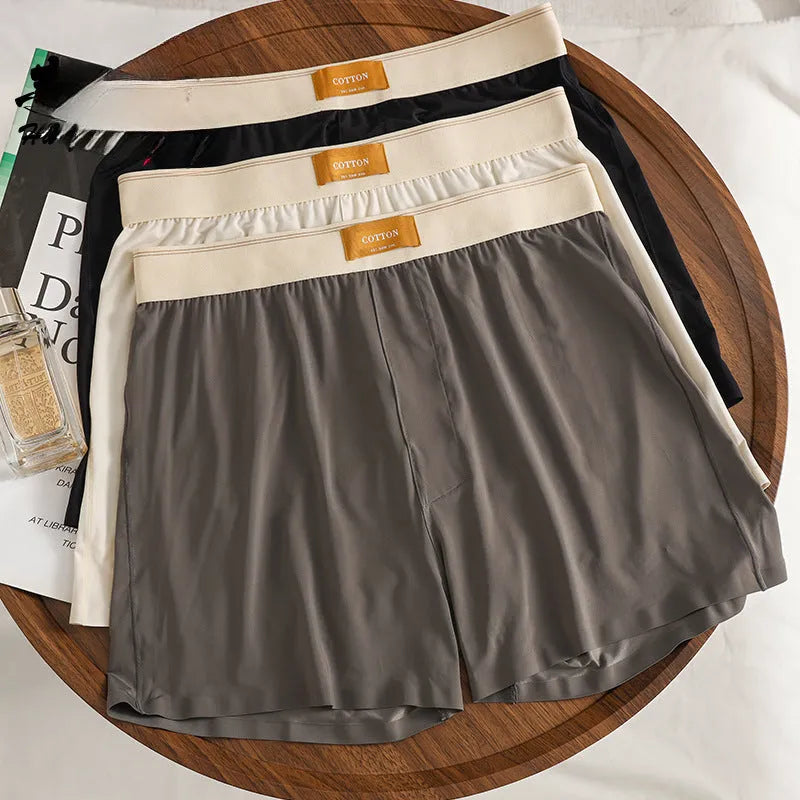 Men's solid colour loose ice silk underwear in a pack of three, shown in beige, black, and grey.