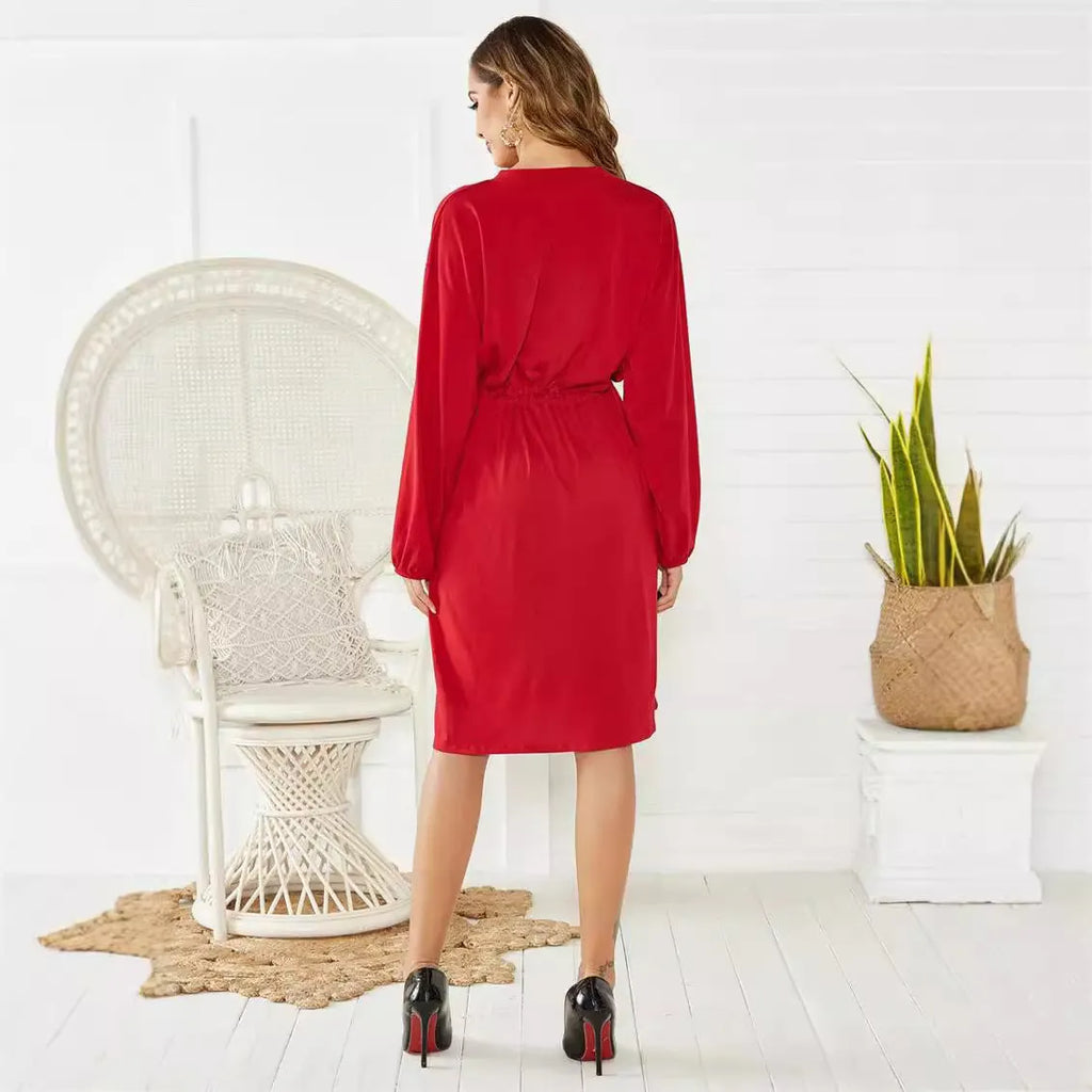 A black A-line midi dress with long sleeves, elasticated cuffs and waist, shown with a belt.