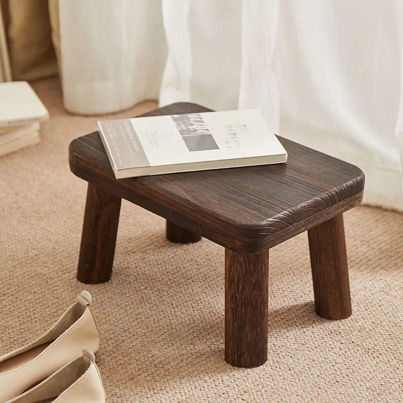 Solid wood distressed finish shoe changing stool with bracket structure for the living room.