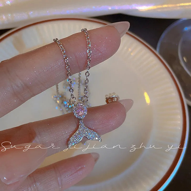 Close-up of a women's sterling silver necklace with a geometric fishtail pendant on an O-ring chain.