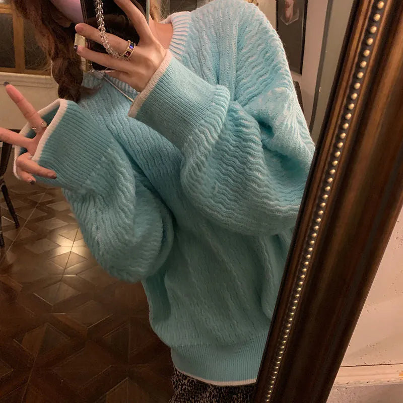 Women's lake blue loose retro pullover sweater on a hanger, showing its regular sleeves and solid colour.
