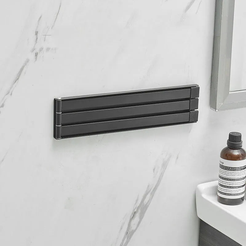 Black folding towel bar with adhesive installation for a no-drill bathroom fit.