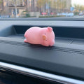 Cute cartoon pig resin ornament for car dashboard decoration on a neutral background.