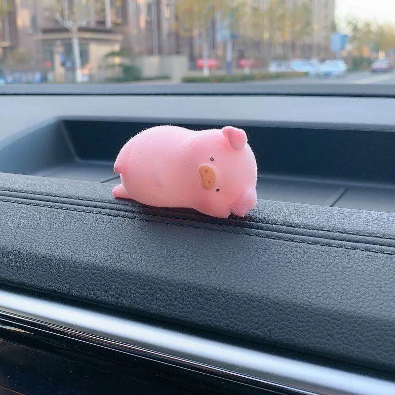 Cute cartoon pig resin ornament for car dashboard decoration on a neutral background.