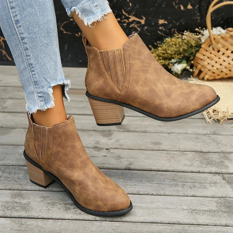 Women's black ankle boots with pointed toe and thick square heel on a rubber sole
