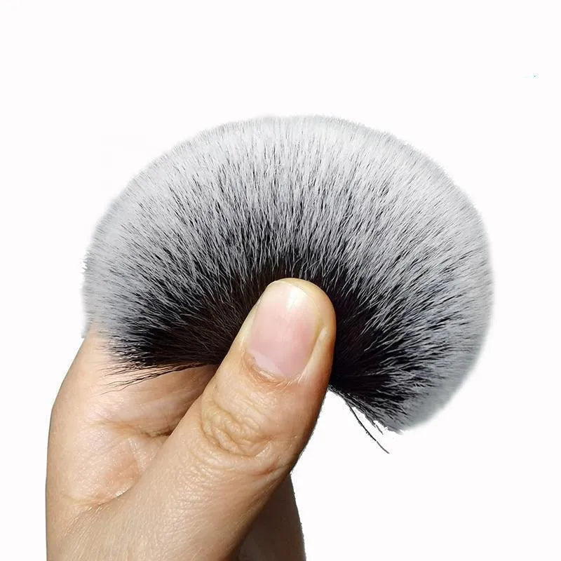 Black ultra-soft pig hair car detailing brush for interior cleaning on a car dashboard.