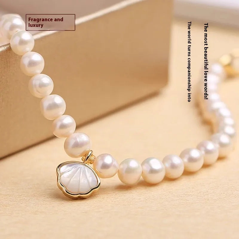 Women's freshwater pearl bracelet with a shell charm on a 16cm elastic string.
